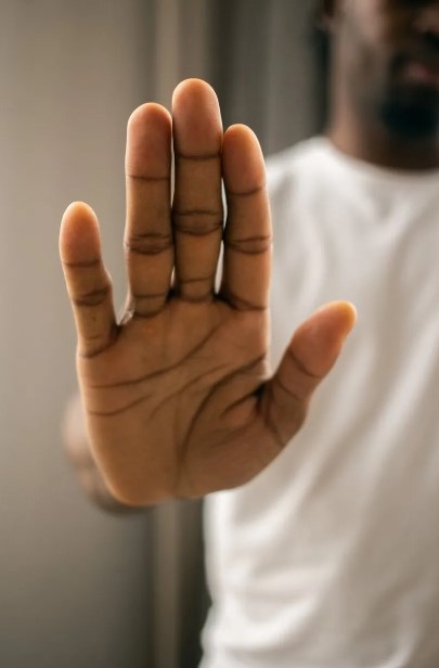 pexels-monstera-production-7114349-9796762 Person holding a hand out in front of them in a stop signal.