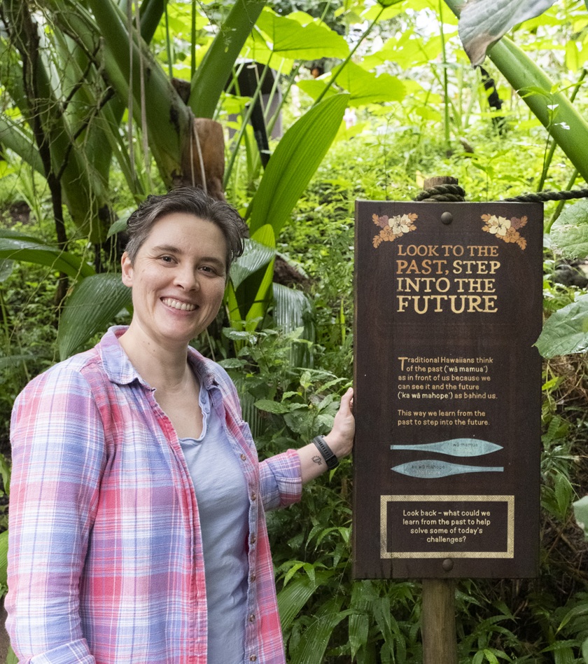 Jaiye standing with a board about honouring the past by stepping into the future at the Eden project.